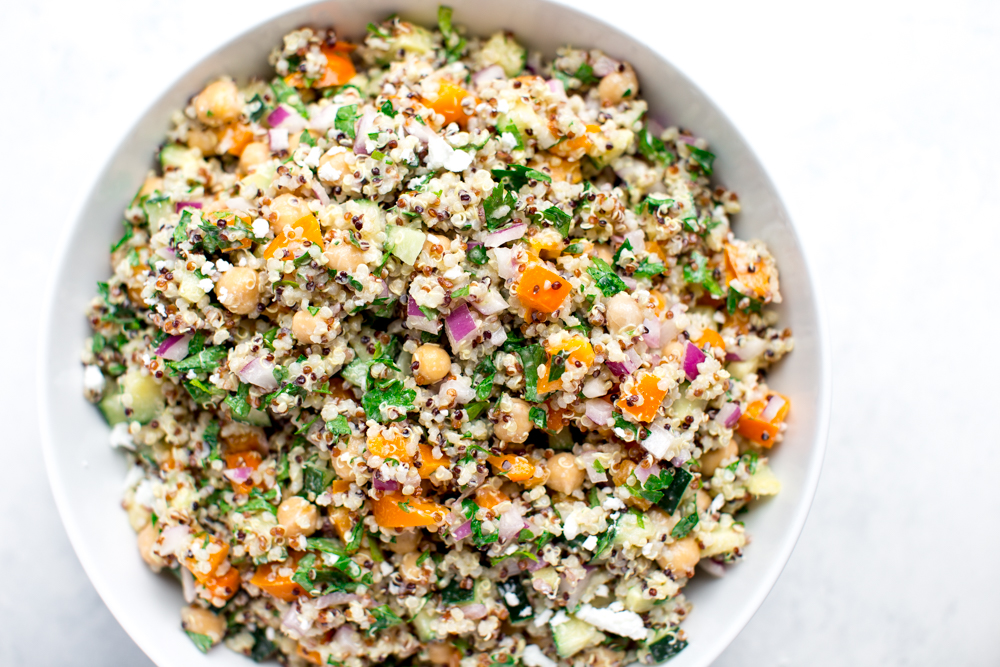 colorful tricolor quinoa salad with parsley, orange bell pepper, chickpeas, red onion and parsley with a creamy feta dressing