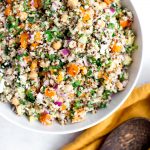 colorful tricolor quinoa salad with parsley, orange bell pepper, chickpeas, red onion with a creamy feta dressing