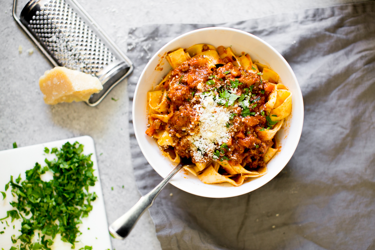 Instant Pot Bolognese pasta and sauce in a bowl with cheese and parsley for garnish
