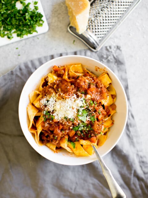 Instant Pot Bolognese pasta and sauce in a bowl with cheese and parsley for garnish