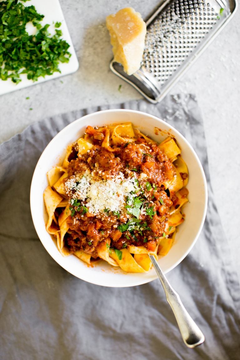 Instant Pot Bolognese pasta and sauce in a bowl with cheese and parsley for garnish