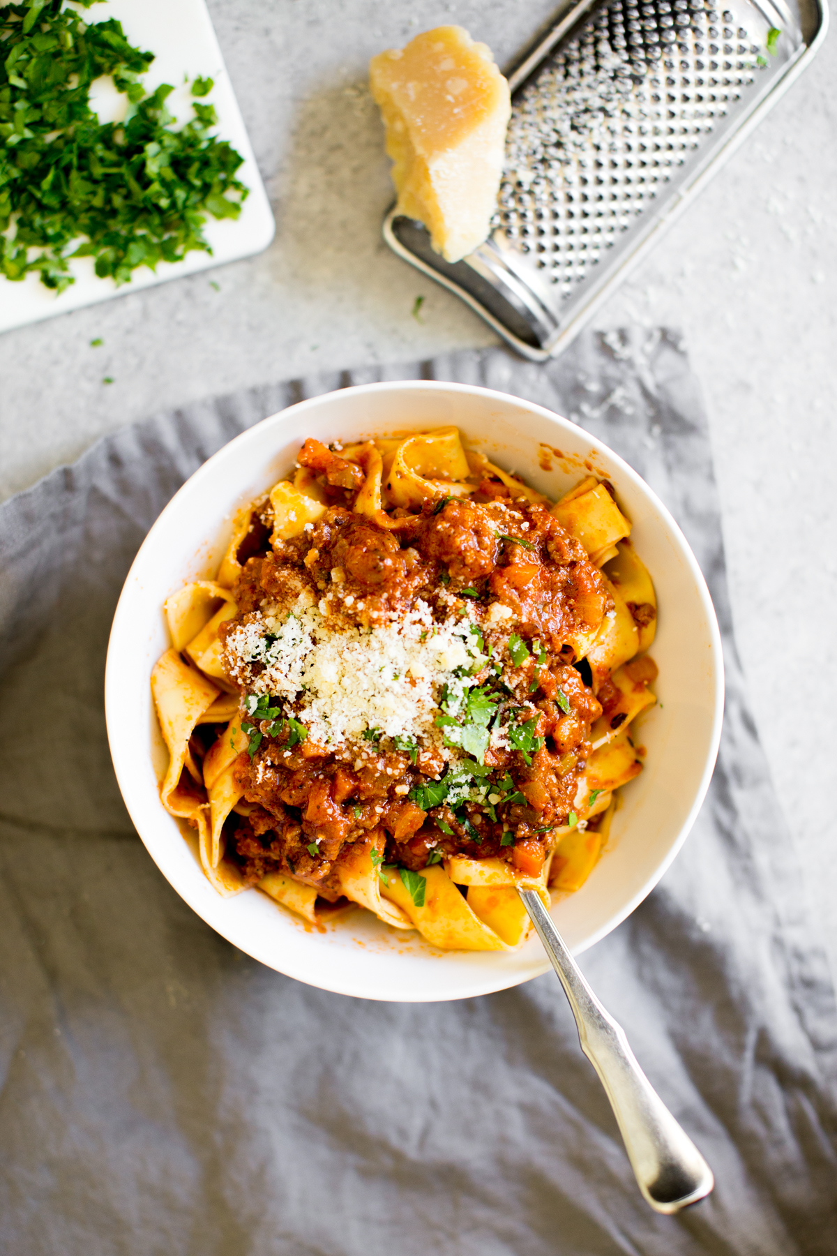 Instant Pot Bolognese sauce with  in a bowl with cheese and parsley for garnish