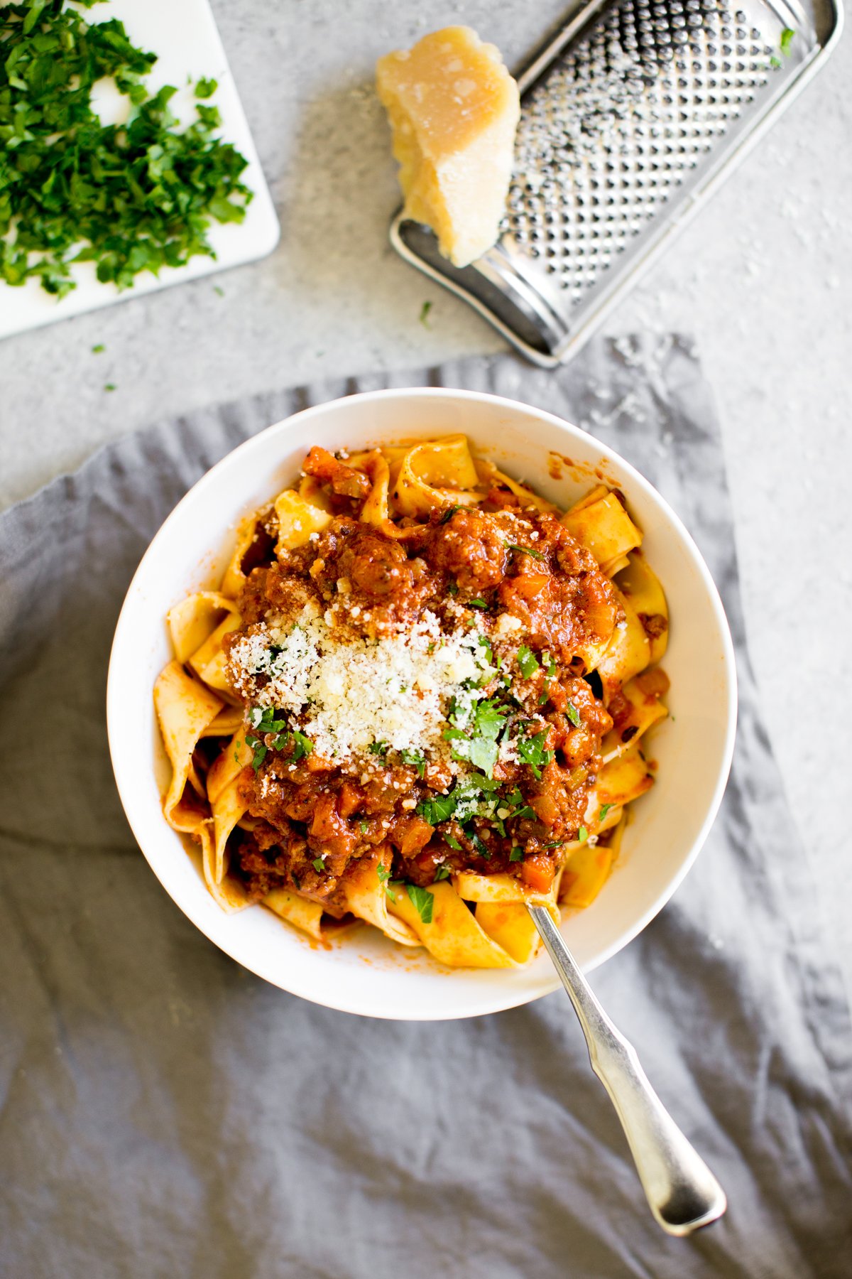 Instant Pot Bolognese sauce with  in a bowl with cheese and parsley for garnish