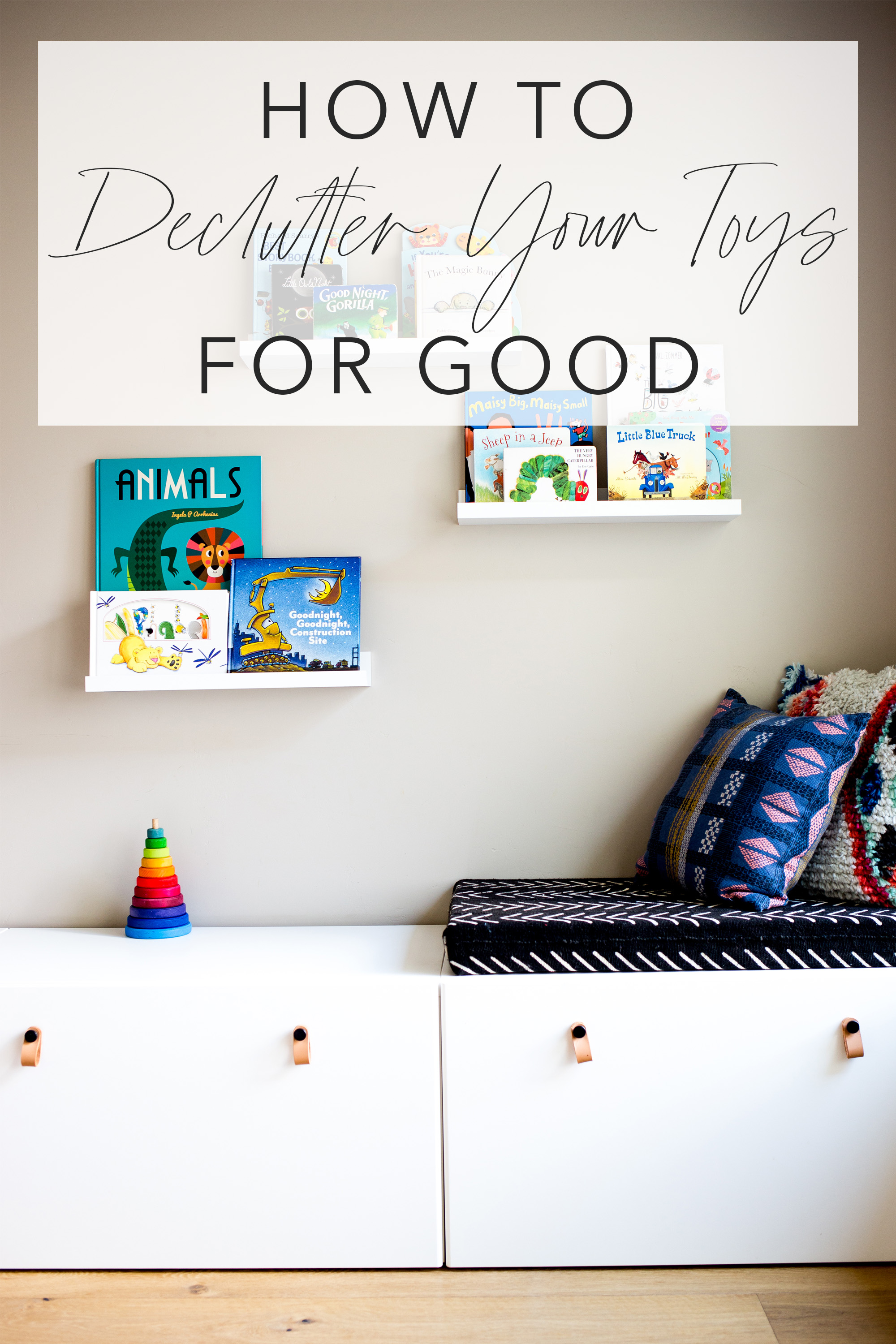 Play room with white modern toy storage bench IKEA and floating white shelves with kids books and title text "how to declutter your toys for good"