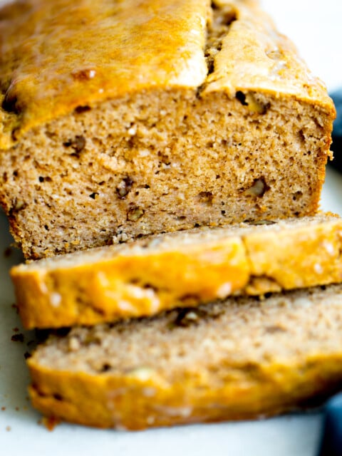 close up photo of a loaf of healthy no added sugar banana bread with two slices cut