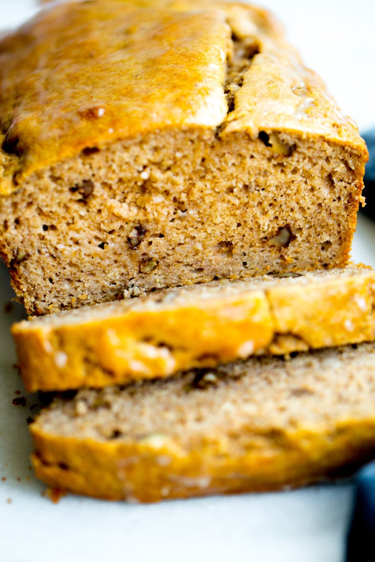 close up photo of a loaf of healthy no added sugar banana bread with two slices cut