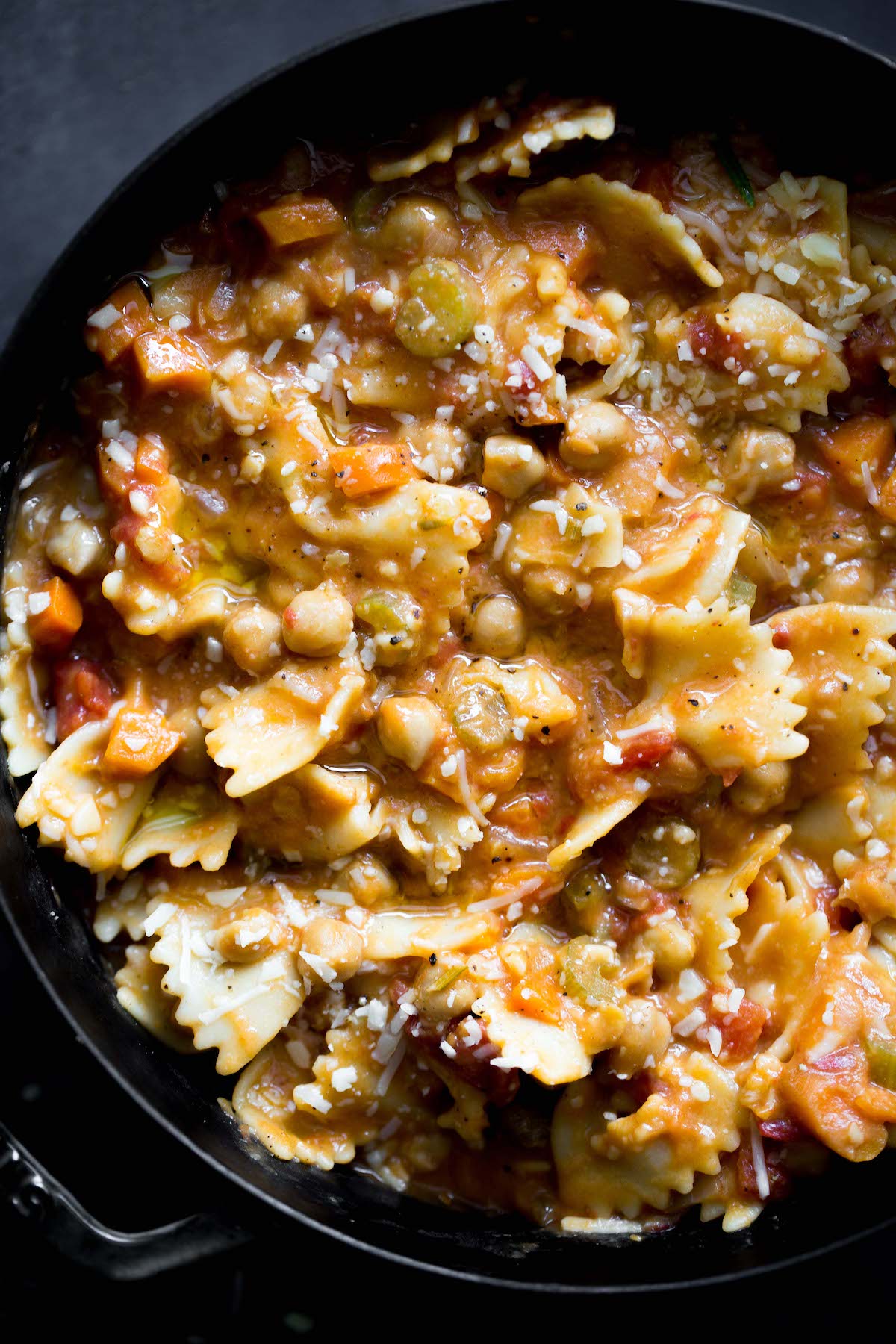 closeup photo of vegetarian pasta e ceci (pasta and chickpeas) in a big pot with dark gray background