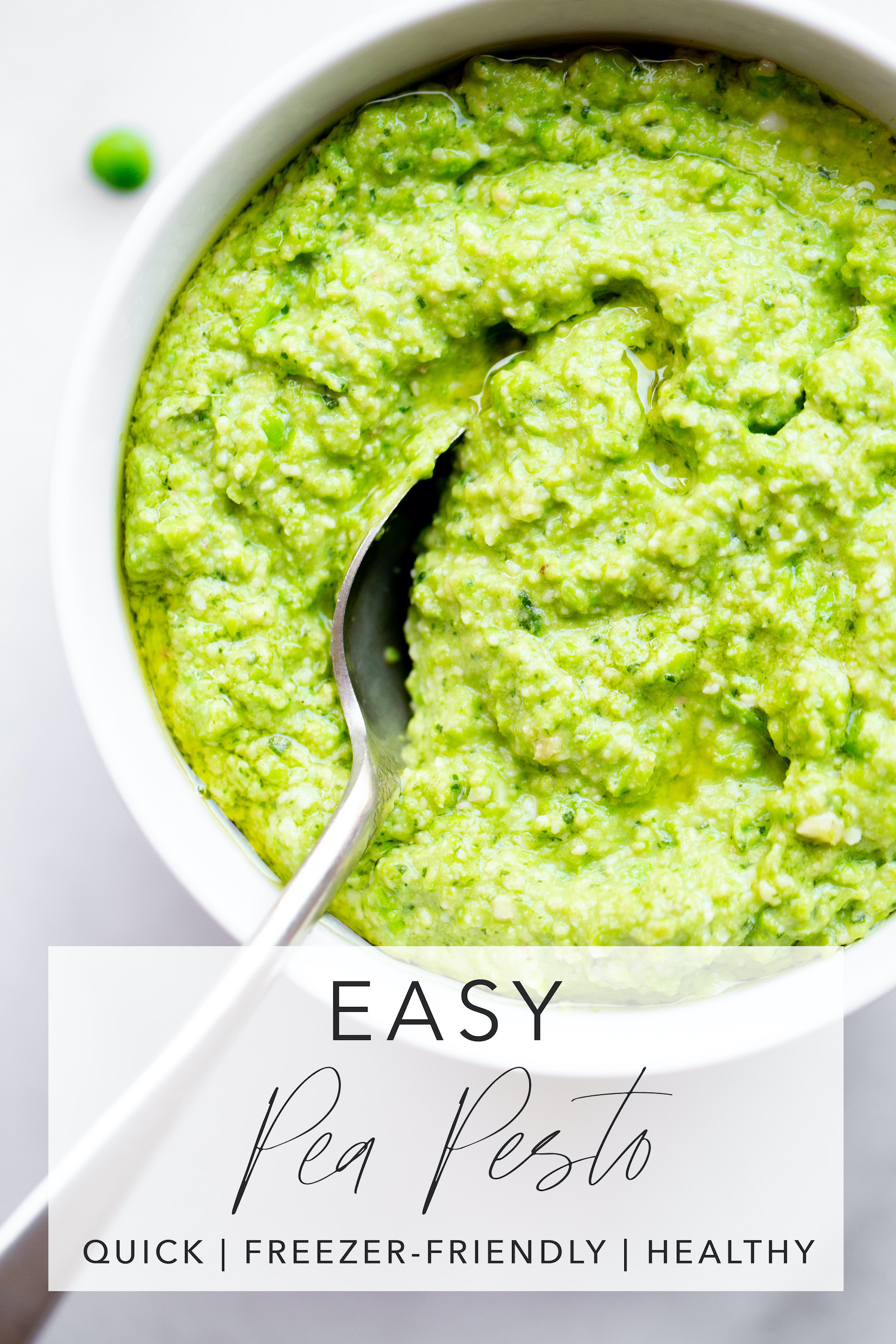 overhead photo of a bowl of pea pesto with a spoon on a white marble background with title text overlay