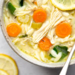 beautiful overhead photo of a bowl of instant pot lemon chicken soup with orzo on a light background with title text overlay