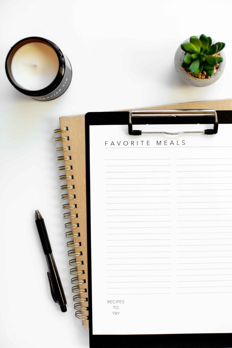 overhead photo of meal planning printable worksheet on white background with pen plant candle