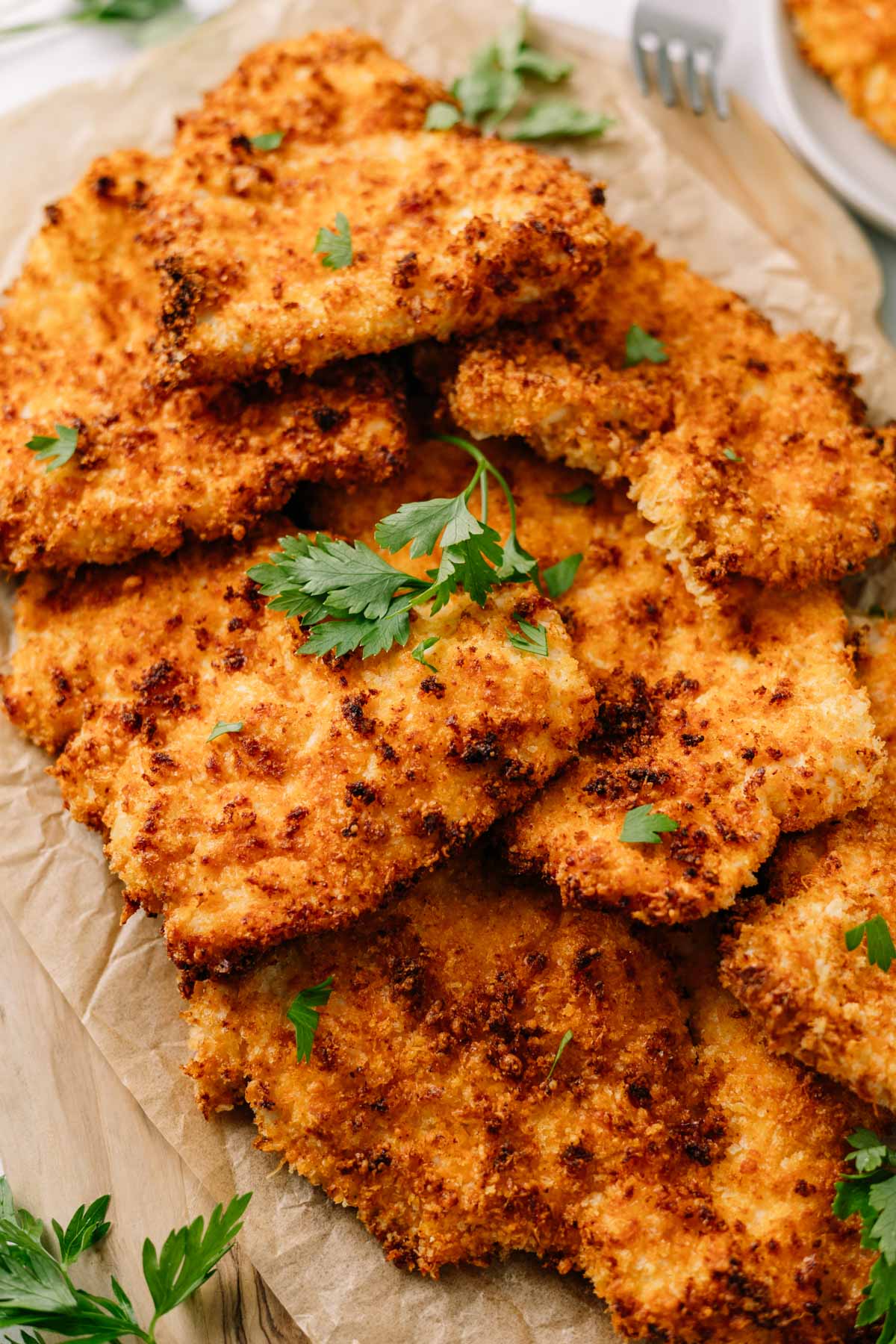 a plate of crispy, closeup of crispy, golden air fryer chicken cutlets on brown paper